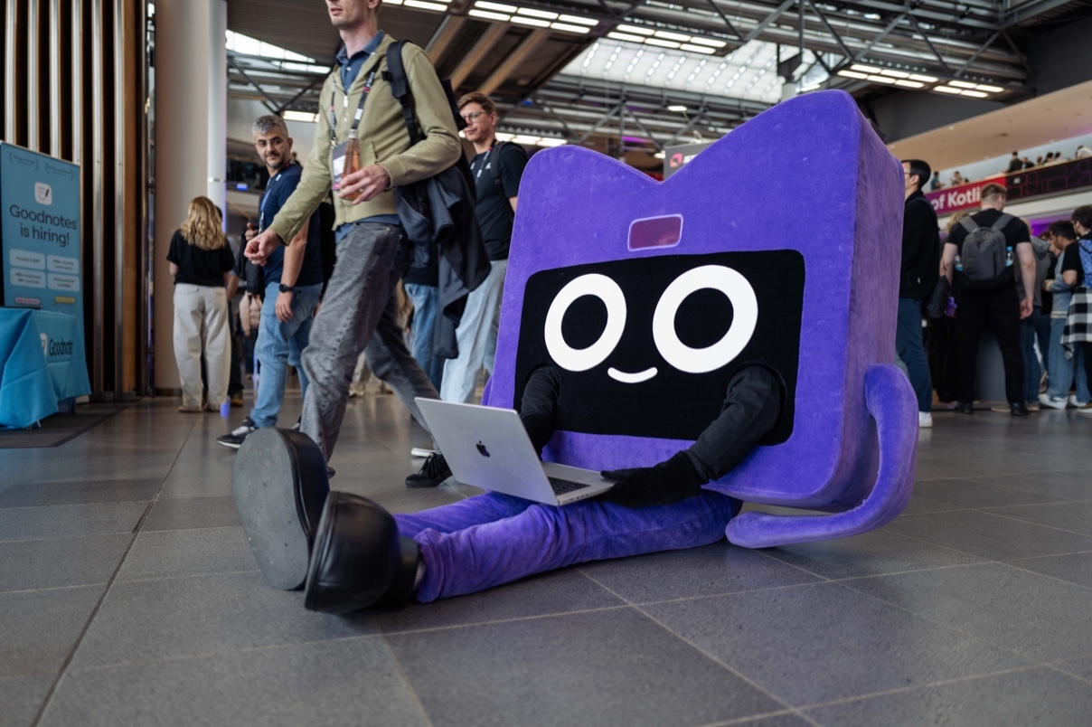 Kodee working on a laptop at KotlinConf 2026